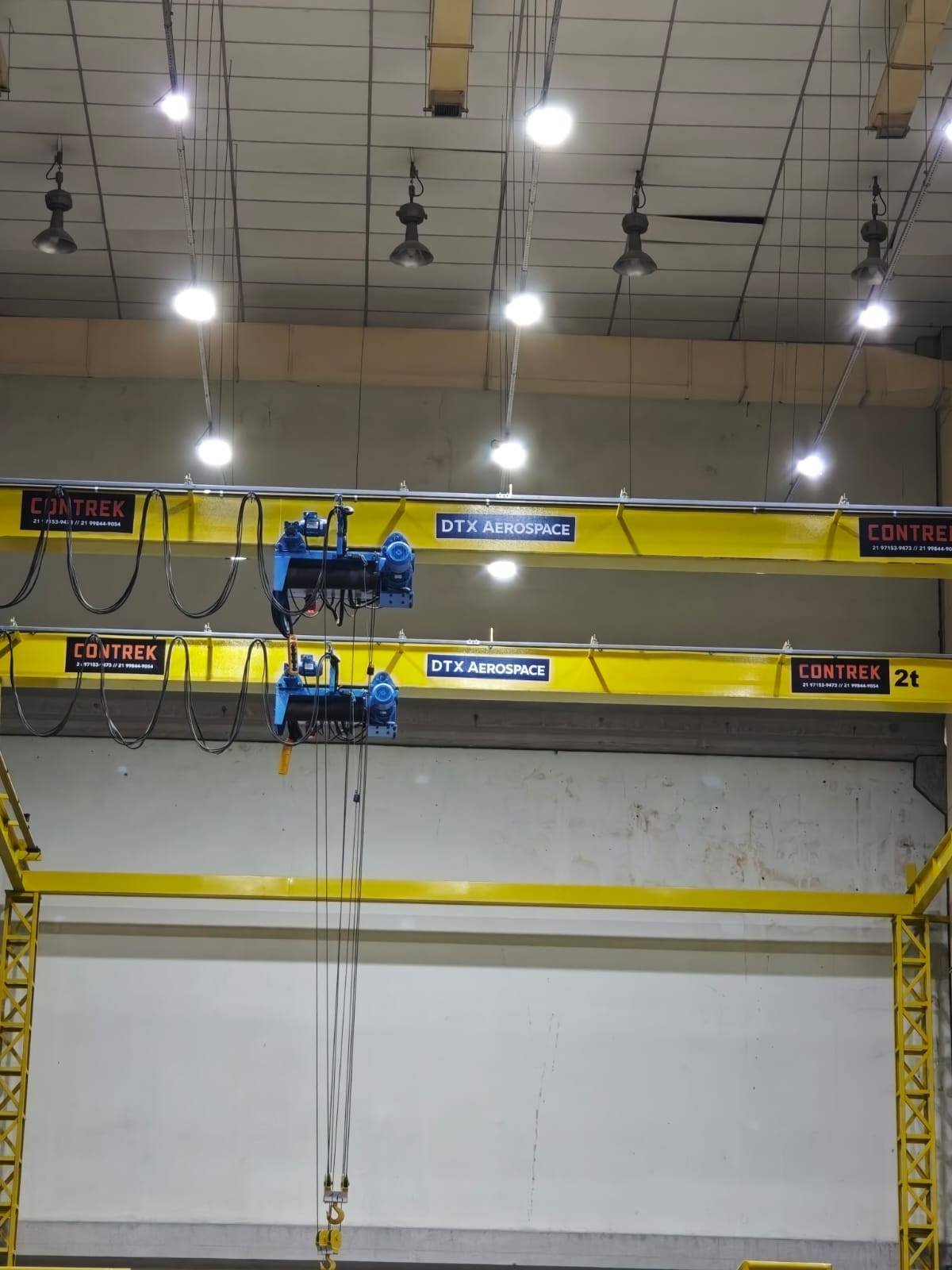 Duas pontes rolantes amarelas instaladas em uma nave industrial